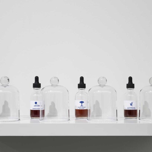 Display of four glass bottles with molecularly formulated scents on white shelf.