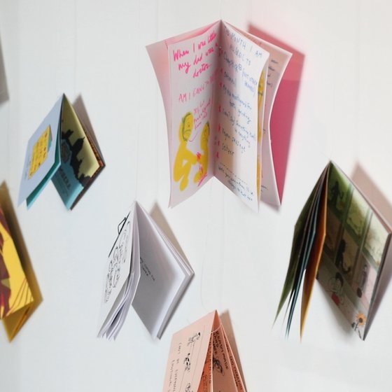 An installation of colorful comics suspended in a white space.