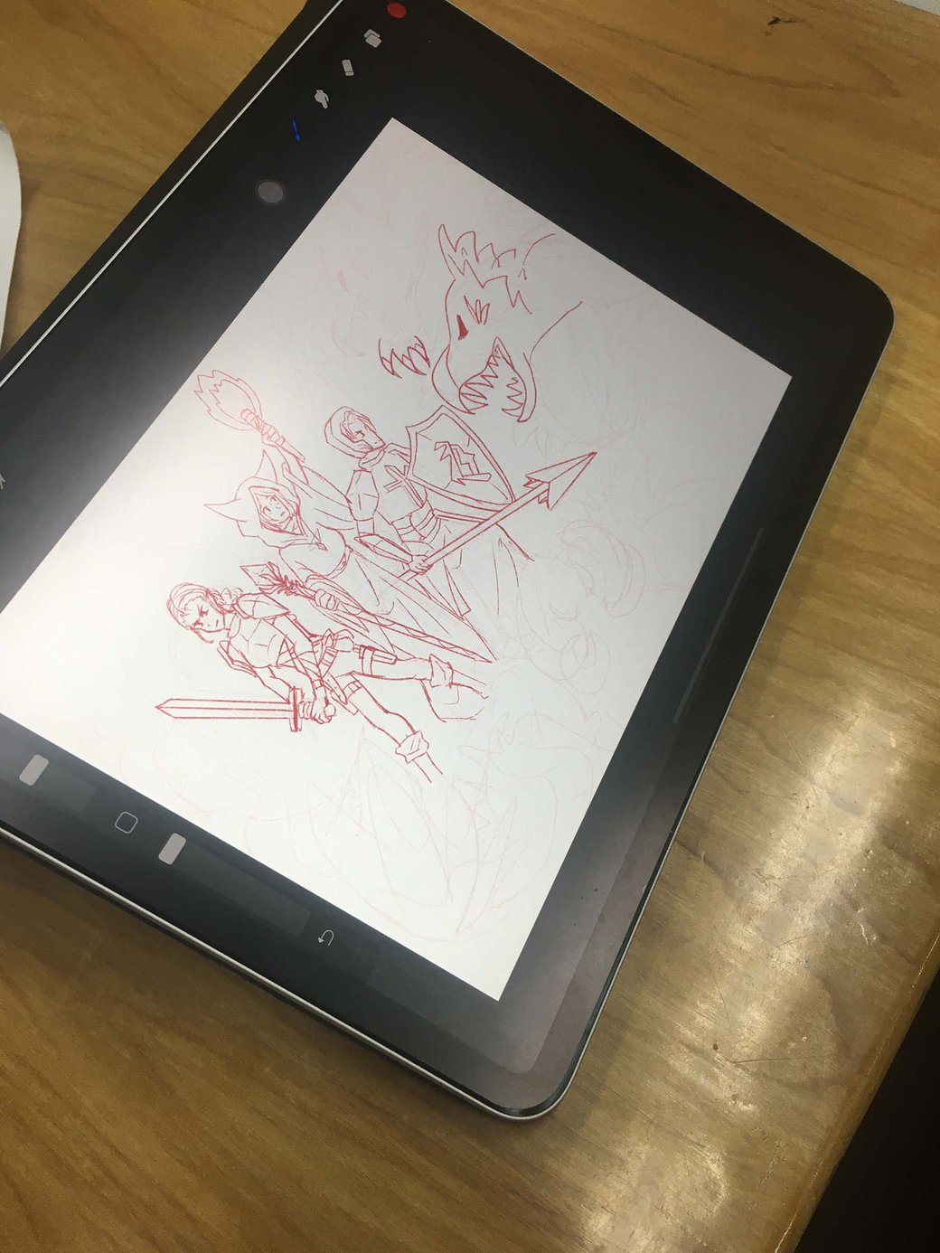 A tablet shows a sketch of medieval characters with swords and armor facing a dragon.