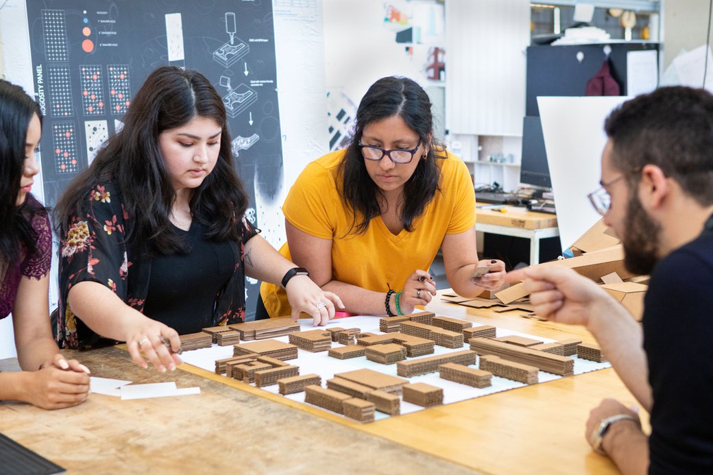 B'Arch students working together on a cardboard model.