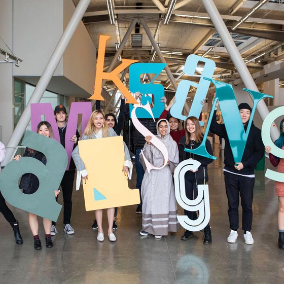 Mark Fox's 'identity' class poses with their 3 foot tall letters in the Nave