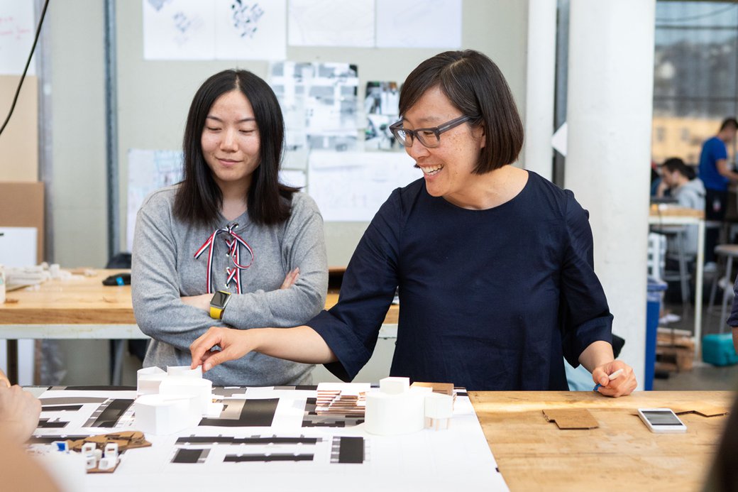 Janette Kim smiling while giving critique to a student..