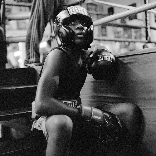 Young boxer sitting on a bench at the boxing gym.