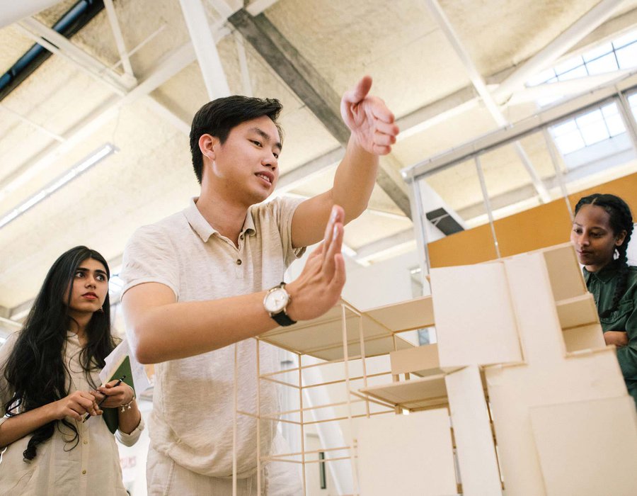 A student displays the size of a model with their hands.