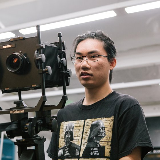 In class, a BFA Photography student directs a photoshoot using a film camera