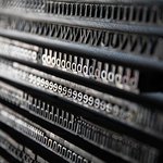 A close-up of a letterpress with the letters T, W, d, e, and h repeating.
