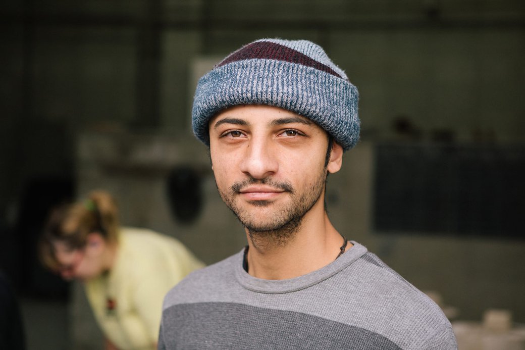 A male student in a stocking cap poses against a blurred background.