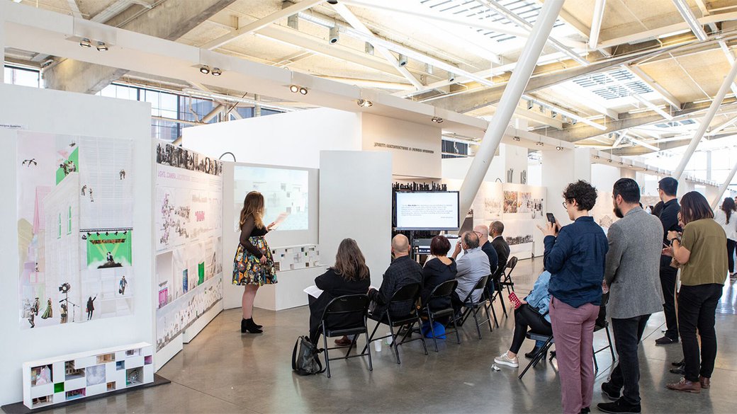 An architecture student presents to a group of faculty.