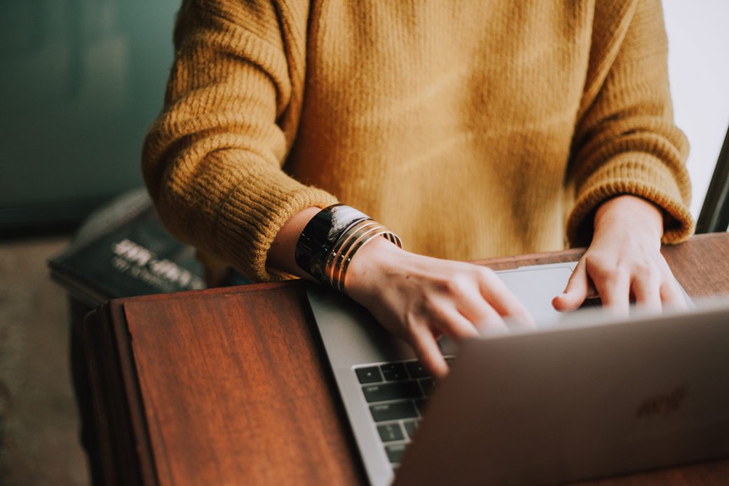 A pair of hands typing on a laptop.