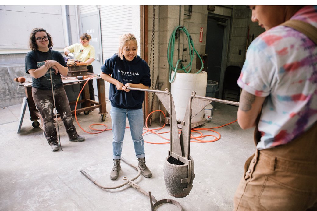 Sculpture student preparing to pour liquid bronze in the metal foundry.