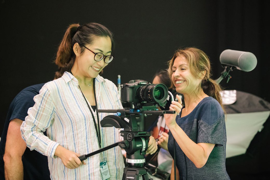 Reflected light from the greensweep casts a pallid glow upon the gleeful faces of film students as they compose their shot.