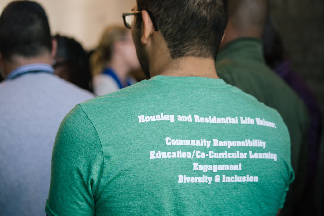 Back of green -colored t-shirt with printed white type.