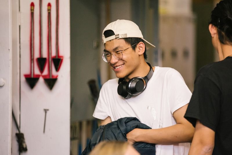 Glass blowing student laughing in the Hot Shop during class