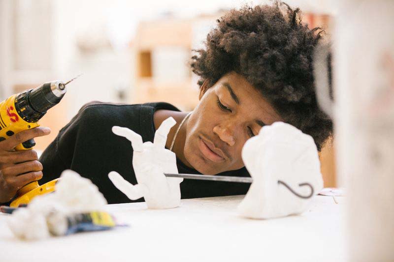 Student screwing together a ceramic sculpture in the mold lab.